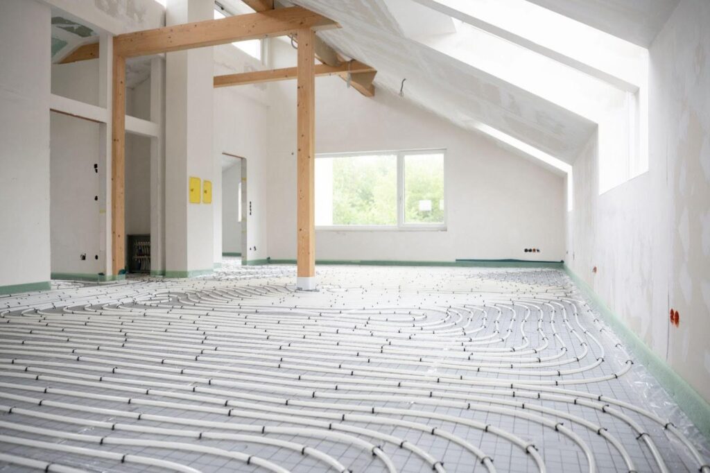 A room featuring visible heating pipes and a central heating system installed on the wall