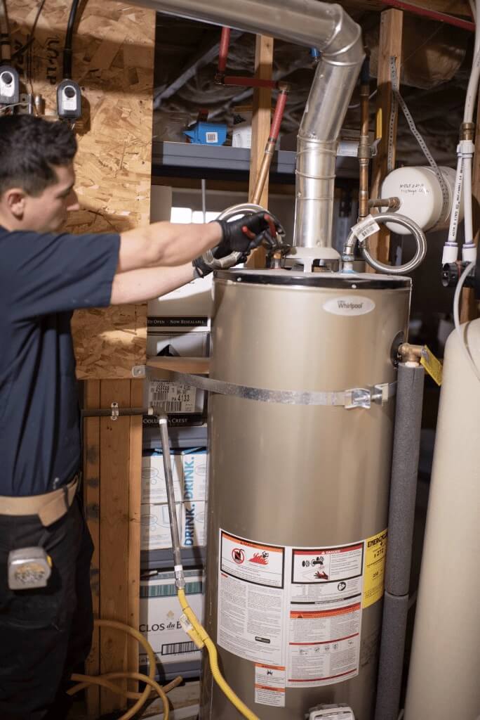 A plumber fixing a leaky pipe in a bathroom.