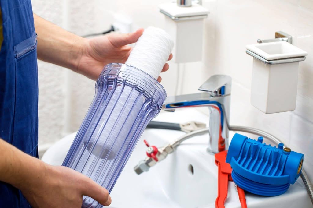 A man displays a plastic container equipped with a water filter emphasizing its role in purifying water