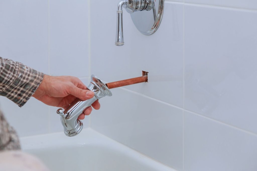 A white bathtub with a faucet and showerhead. Plumbing issues may be causing problems with the bathtub