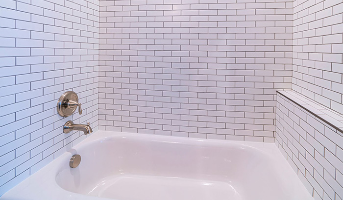 A Small Bathroom With A White Bathtub. Relevant To Bathtub Issues And Plumbing