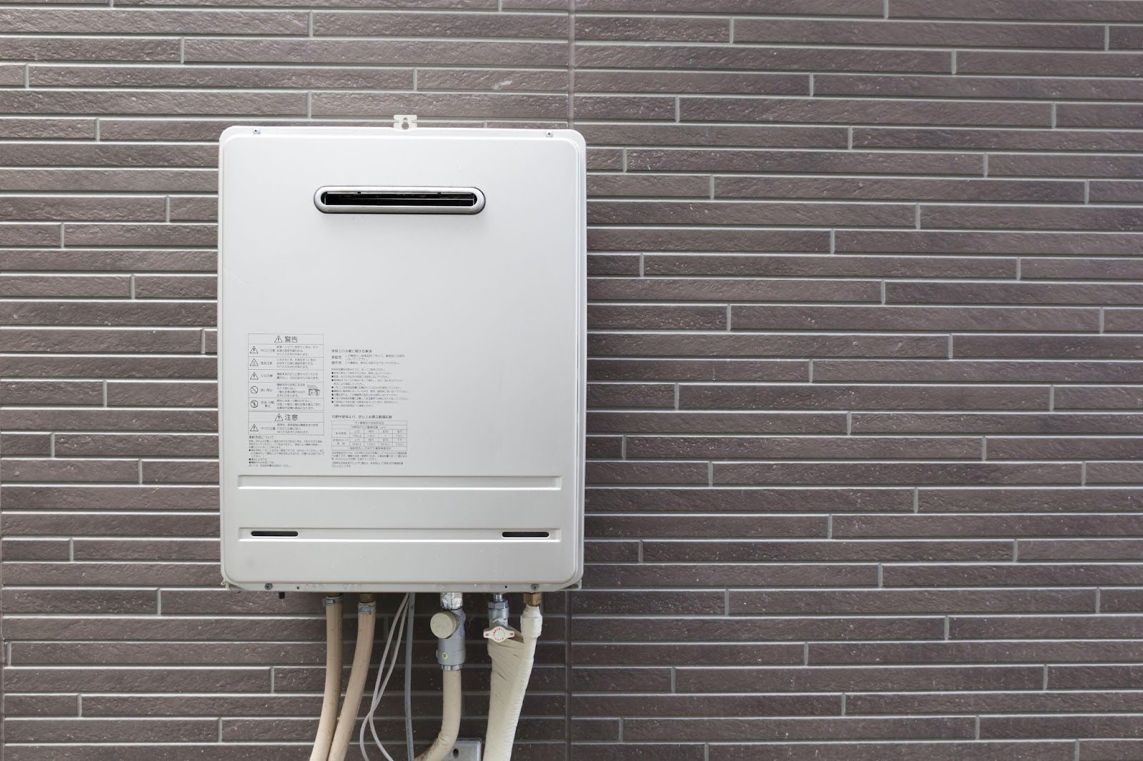 A gas water heater is securely mounted on a wall showcasing its compact design and efficient installation
