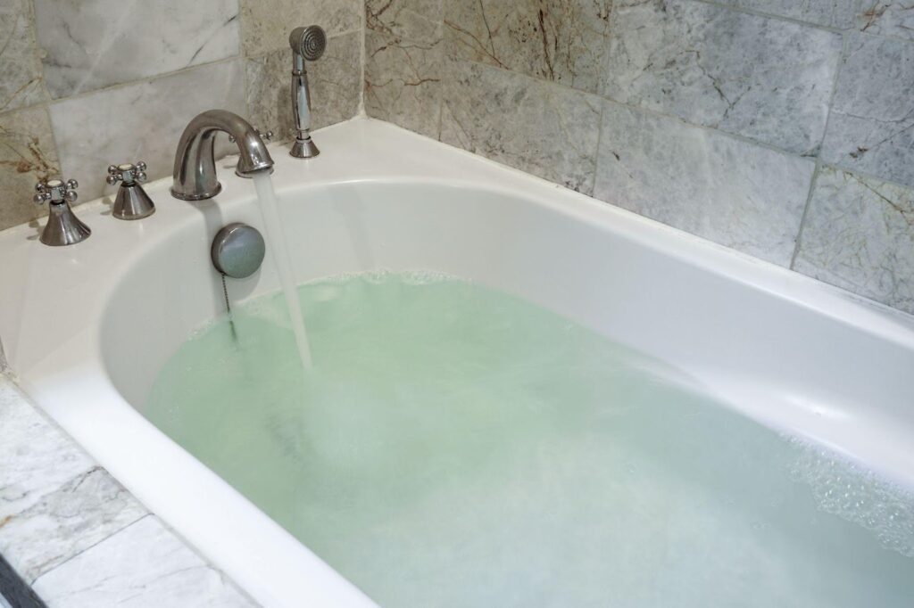 A bathtub filled with green water creating a vibrant and unusual visual effect
