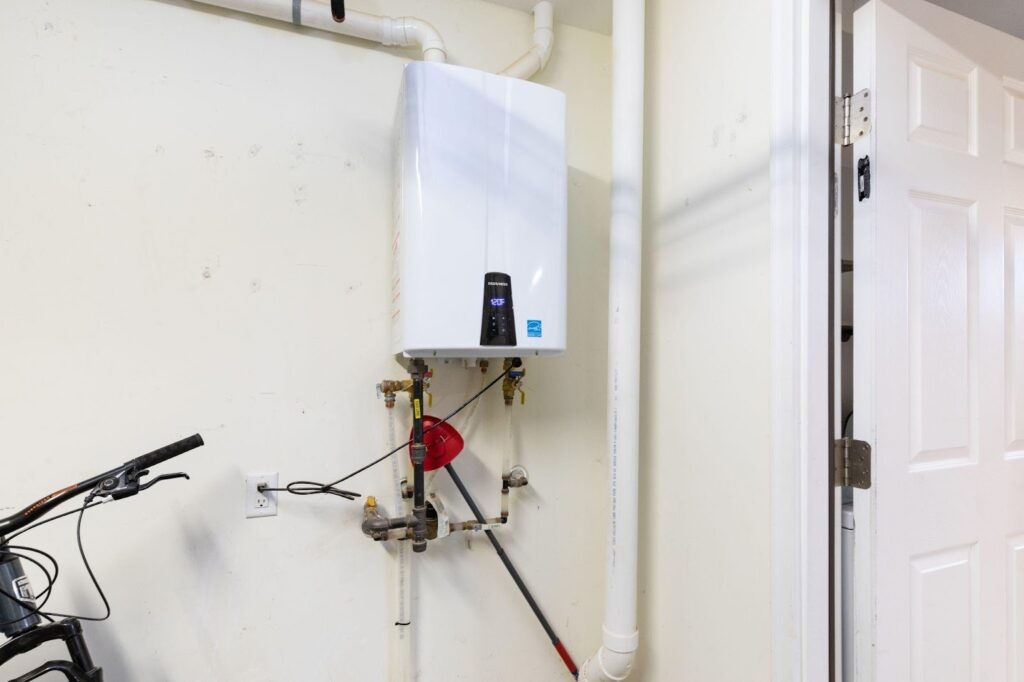 A bike stands next to a wall-mounted water heater