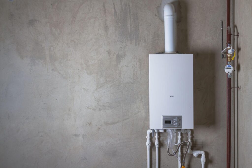 A gas boiler installed in a room surrounded by various pipes connected to the heating system