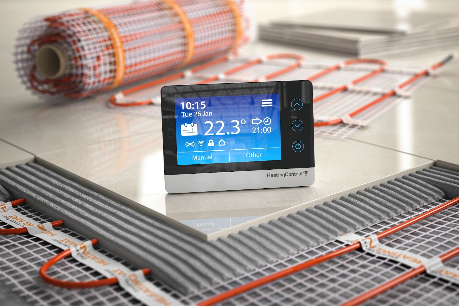 A digital thermostat placed on the floor, designed for controlling radiant floor heating systems.