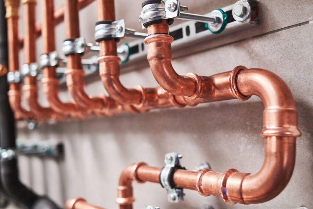 A wall featuring copper pipes and valves illustrating essential plumbing components in a building