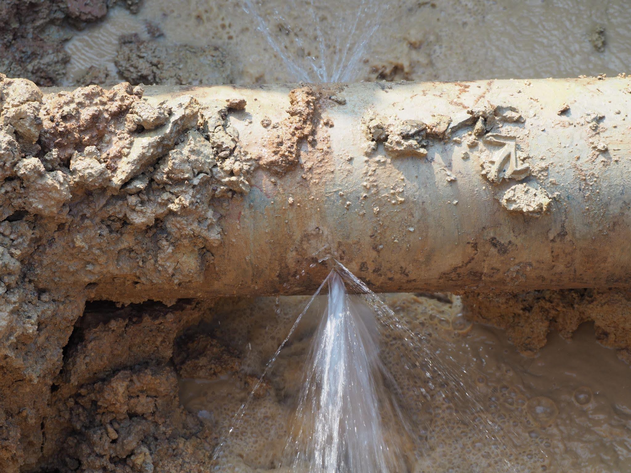 A pipe releasing a steady stream of water illustrating a flow from the opening